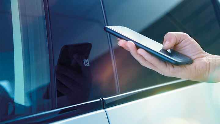 Detailný záber na aplikáciu My Honda+ osoby používajúcej telefón mimo vozidla
