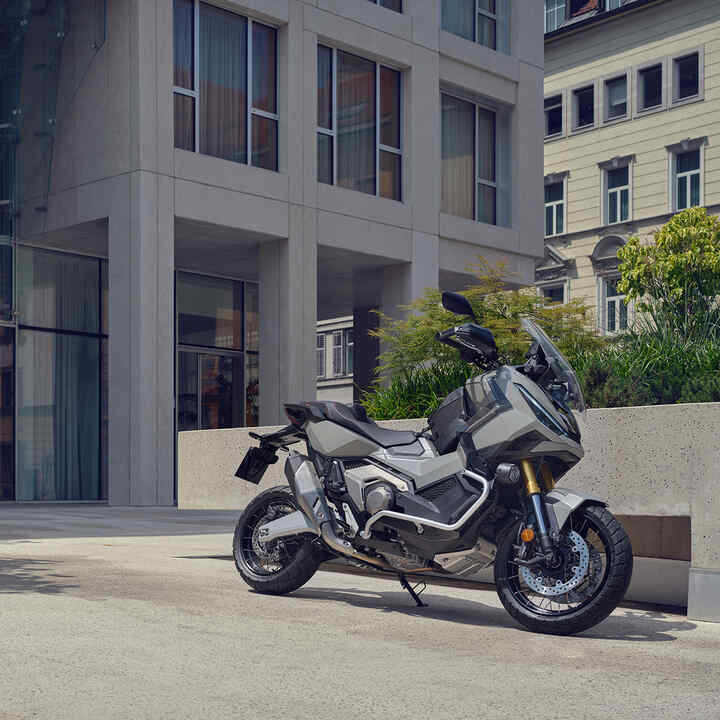 Motocykel X-ADV zaparkovaný na príjazdovej ceste v meste.
