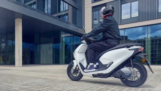 Figurant na skútri Honda CUV e: predvádza jednoduchú asistenciu pri cúvaní.