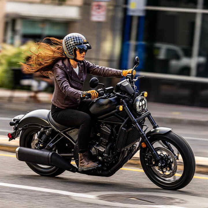 Figurant na motocykli Honda CMX1100 v meste.